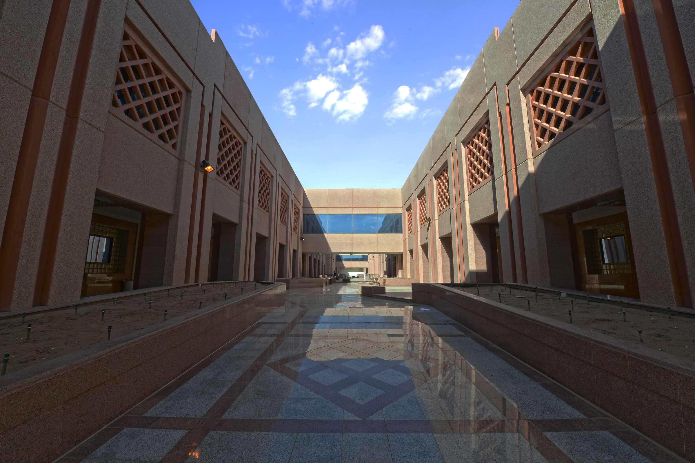 Architectural passage between Taibah University buildings under a blue sky